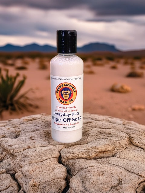 Bottle of Funky Monkey soap on a rocky surface with desert landscape in the background