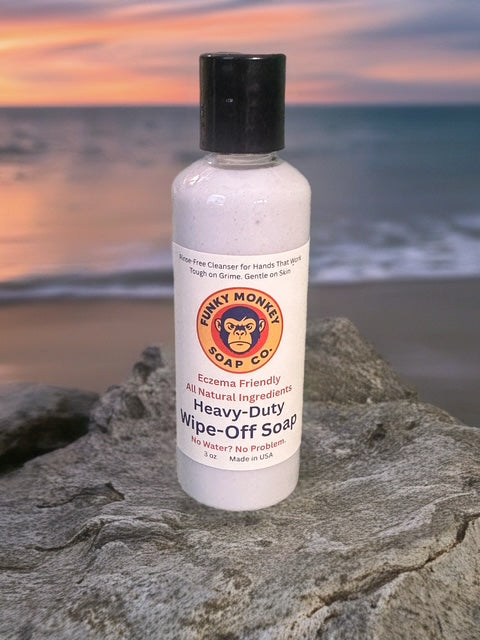 Bottle of Funky Monkey Soap Co. Heavy-Duty Wipe-Off Soap on a rock with a beach sunset in the background