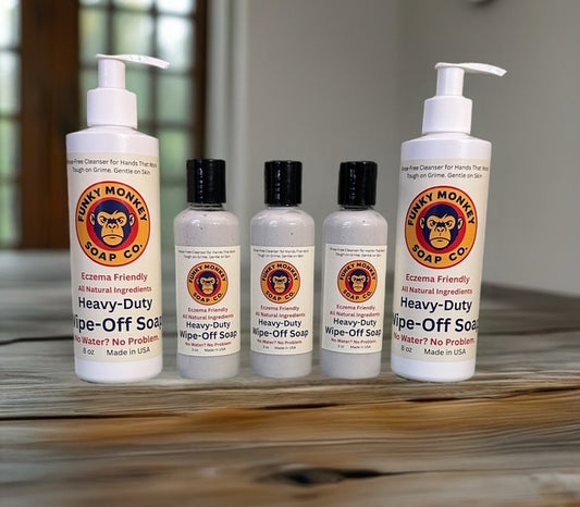 Five bottles of Heavy-Duty Wipe-Off Soap from Funky Monkey Soap Co. on a wooden surface.