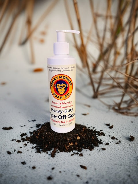 Funky Monkey Soap Co. bottle of heavy-duty wipe-off soap on a sandy surface.