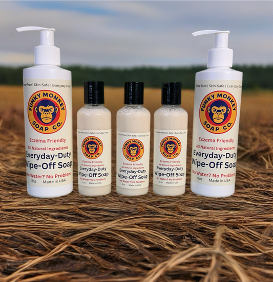 Funky Monkey Soap Co. products on a straw background with a blurred natural landscape.